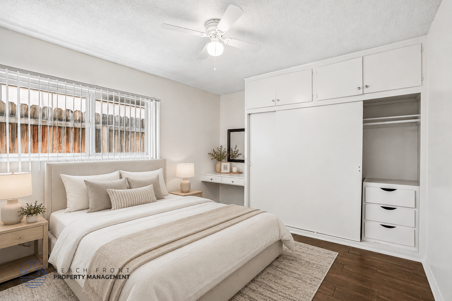 A bedroom with a bed, nightstands, and a window with blinds.